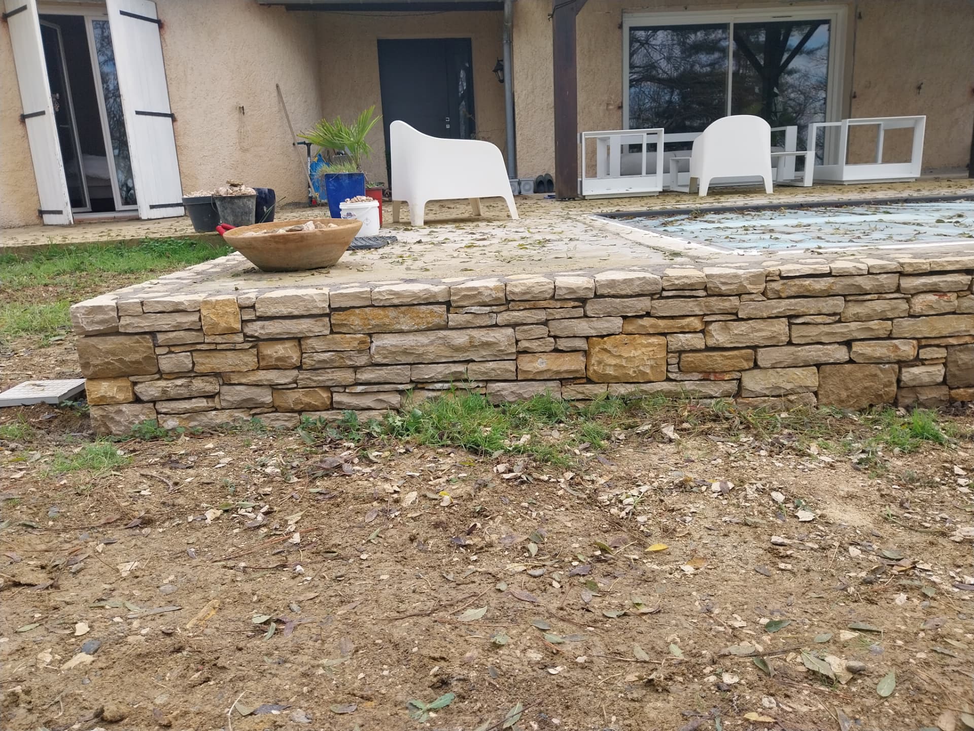 Piscine semi-enterrée en Pierre du Lot avec porte cintrée