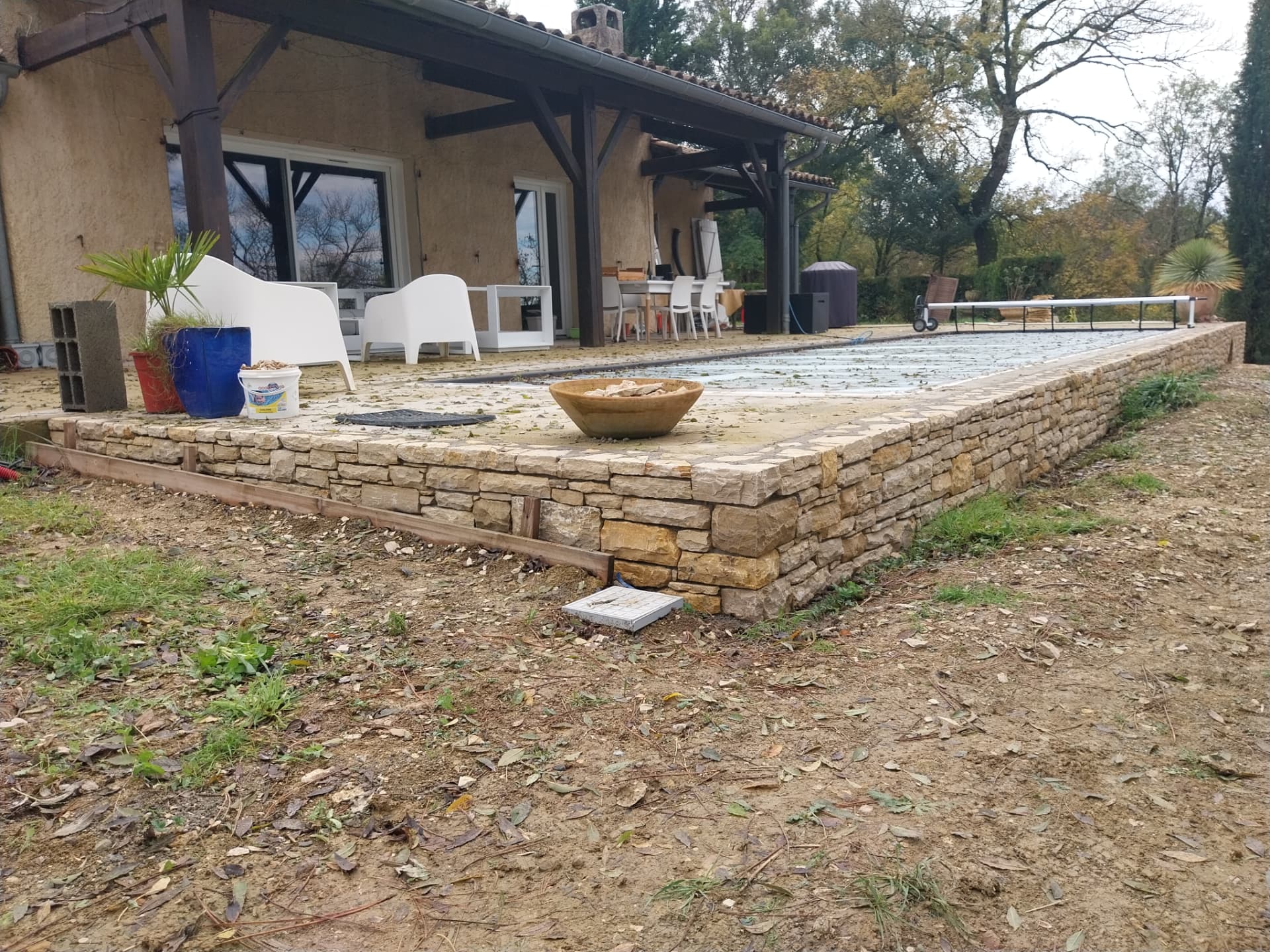 Piscine semi-enterrée en Pierre du Lot avec porte cintrée